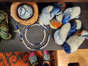 Custom hand-dyed yarn in hanks, one wound into a ball and cast onto circular knitting needles